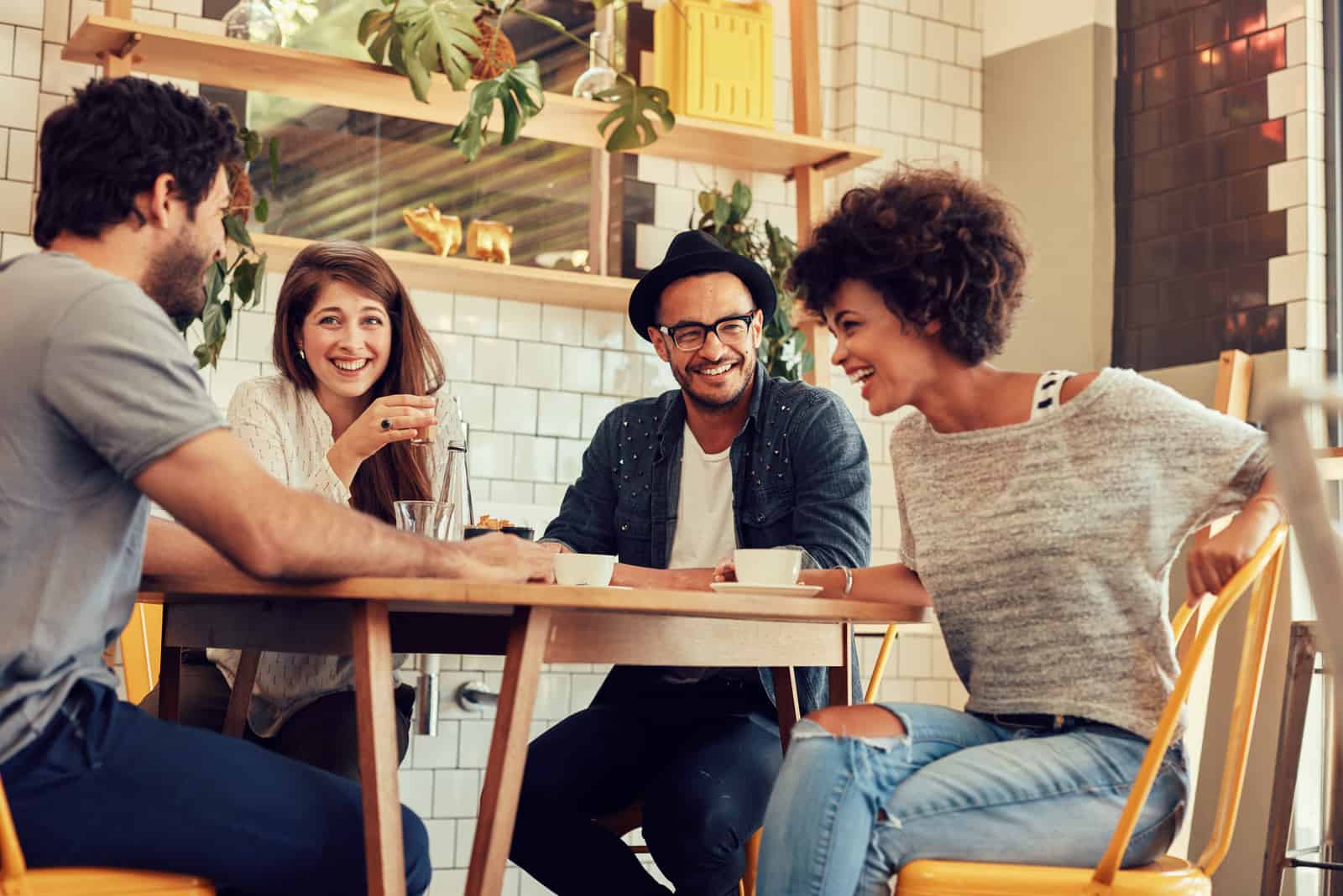 friends sit at a table in a cafe and talk