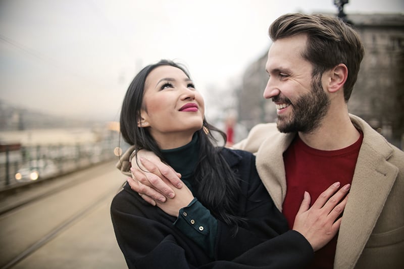 feliz pareja abrazándose durante un paseo