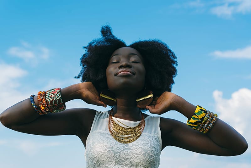 happy woman facing the sky with eyes closed