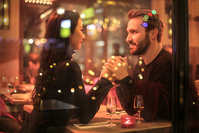 pareja de enamorados cogidos de la mano en un restaurante romántico