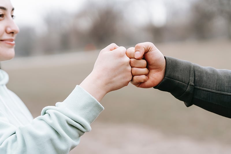 man and a woman greeting each other with fist bump