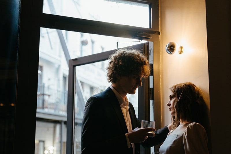 man flirting with a woman while standing near the door