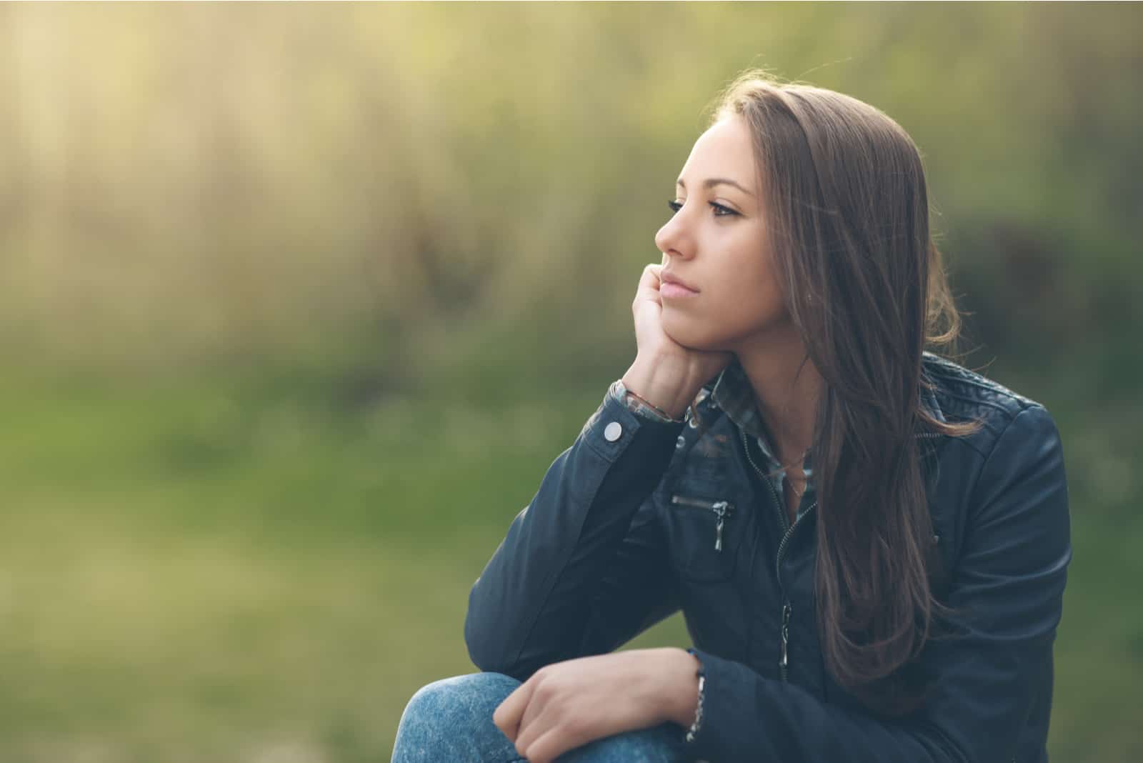 mujer pensativa relajándose en el parque