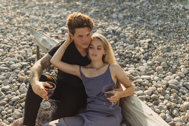 romantic couple drinking wine on the beach