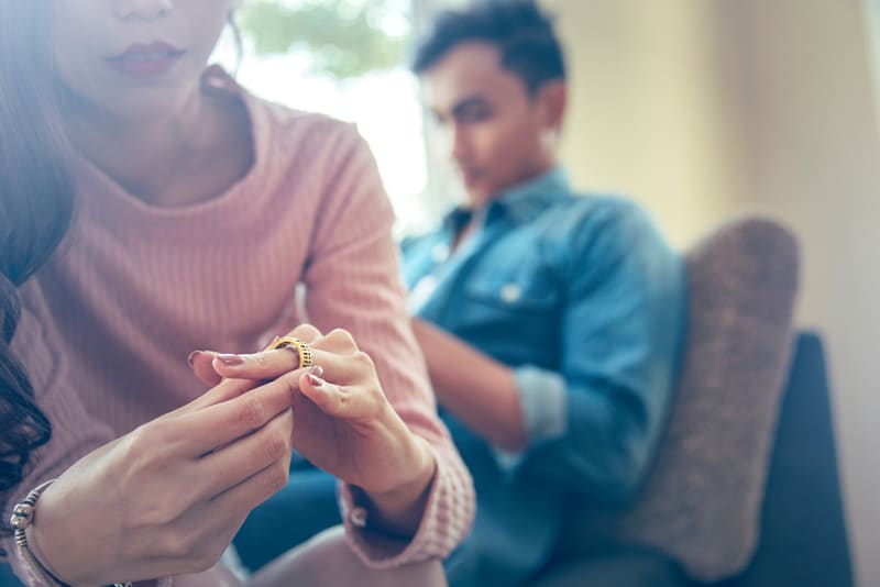 esposa triste sosteniendo el anillo de bodas pensando en el divorcio