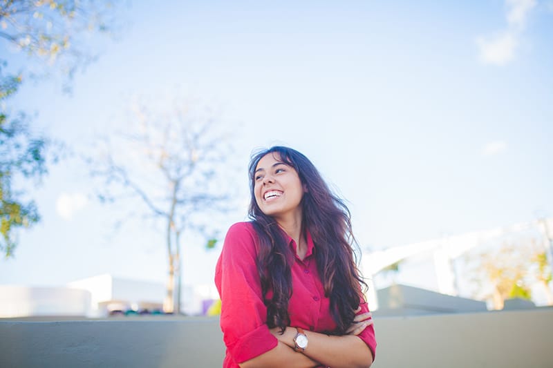 smiling woman with crossed arms looking aside