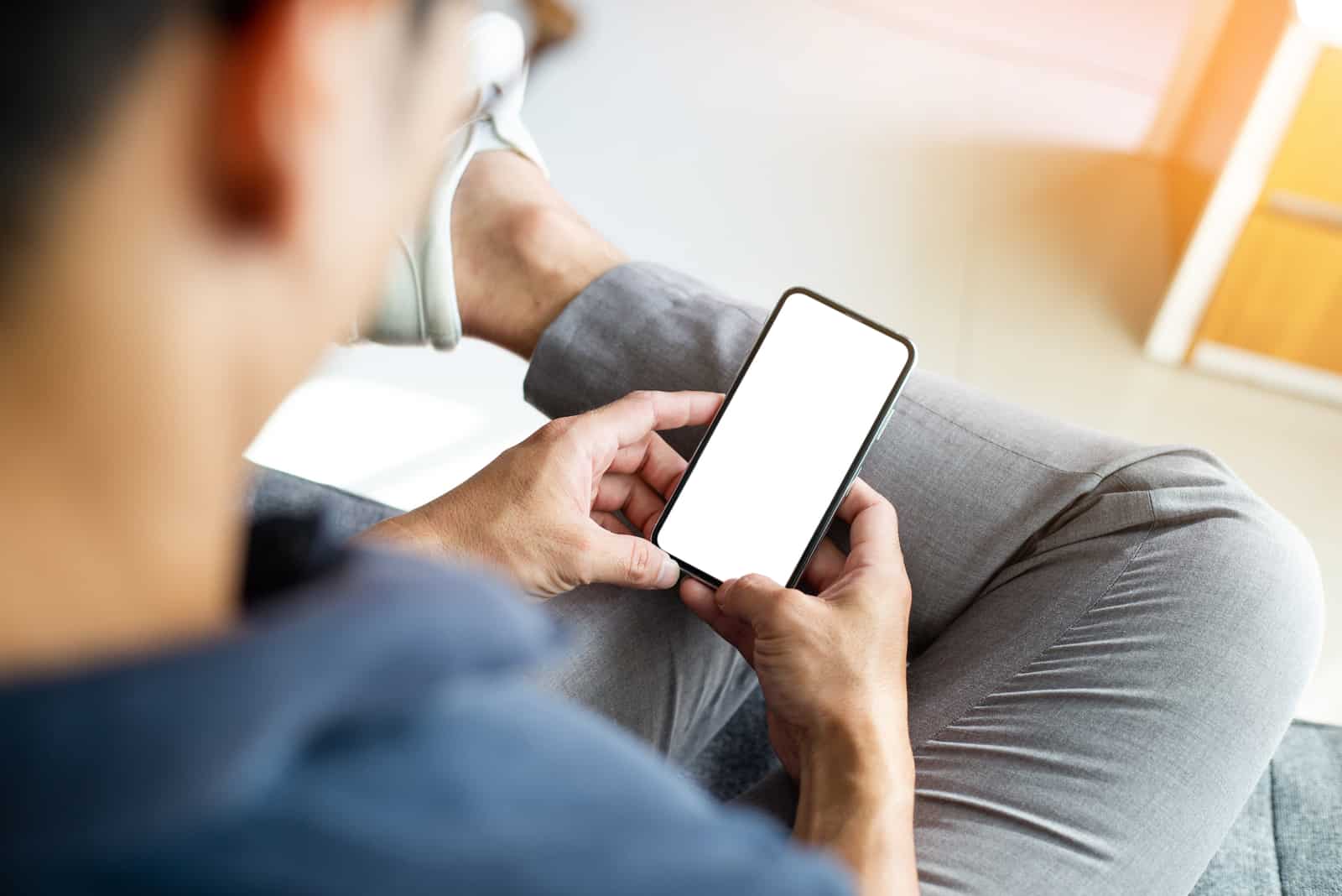 the man sits and holds the phone in his hand