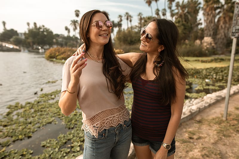 two smiling female friends talking during the walk