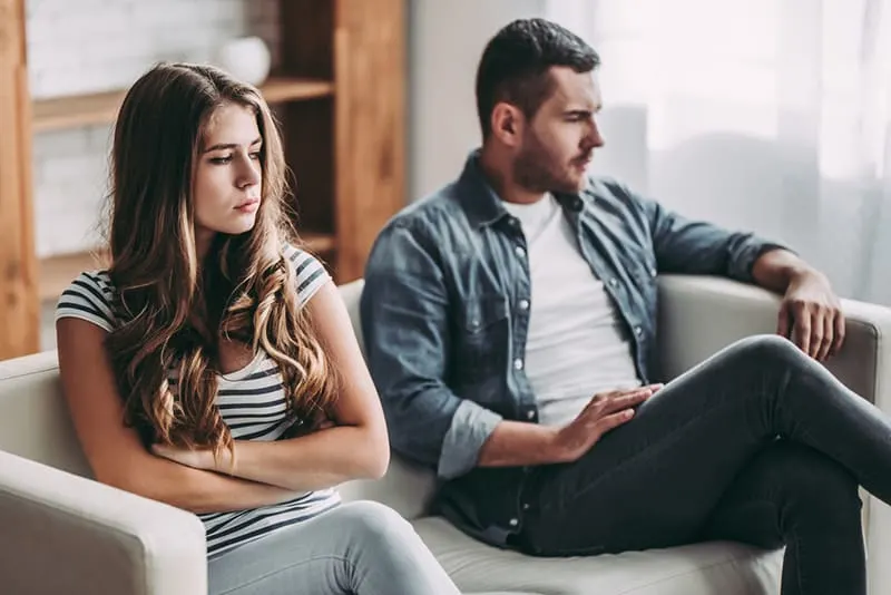 upset couple sitting on the couch without talking