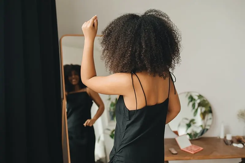 woman in black dress dancing in front of the mirror