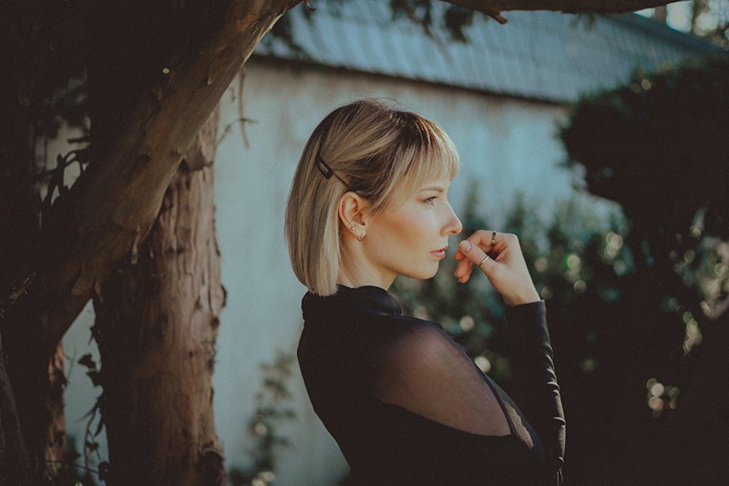 woman standing near the tree looking thoughtful