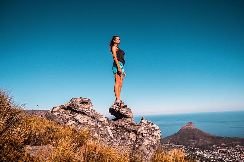 woman standing on stone under the blue sky