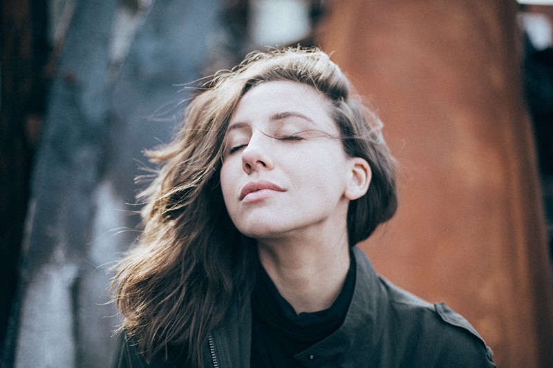 woman with eyes closed standing on the breeze