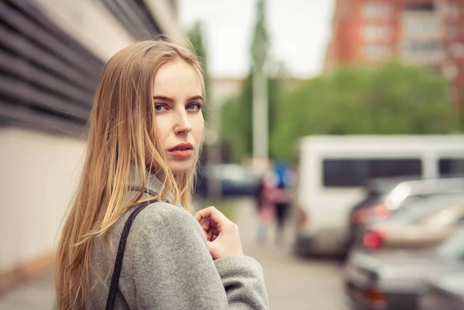 young woman at parking looking back over shoulder