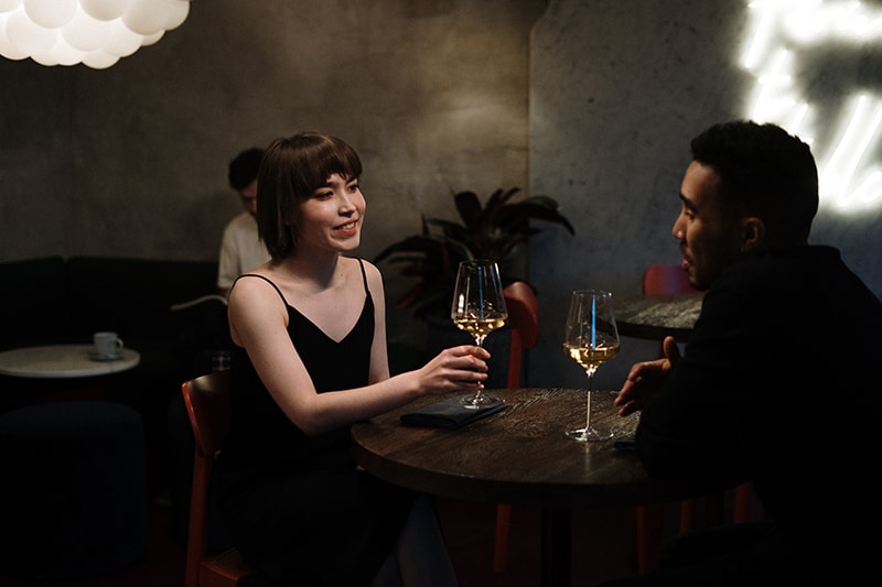man and woman talking and drinking champagne on a date
