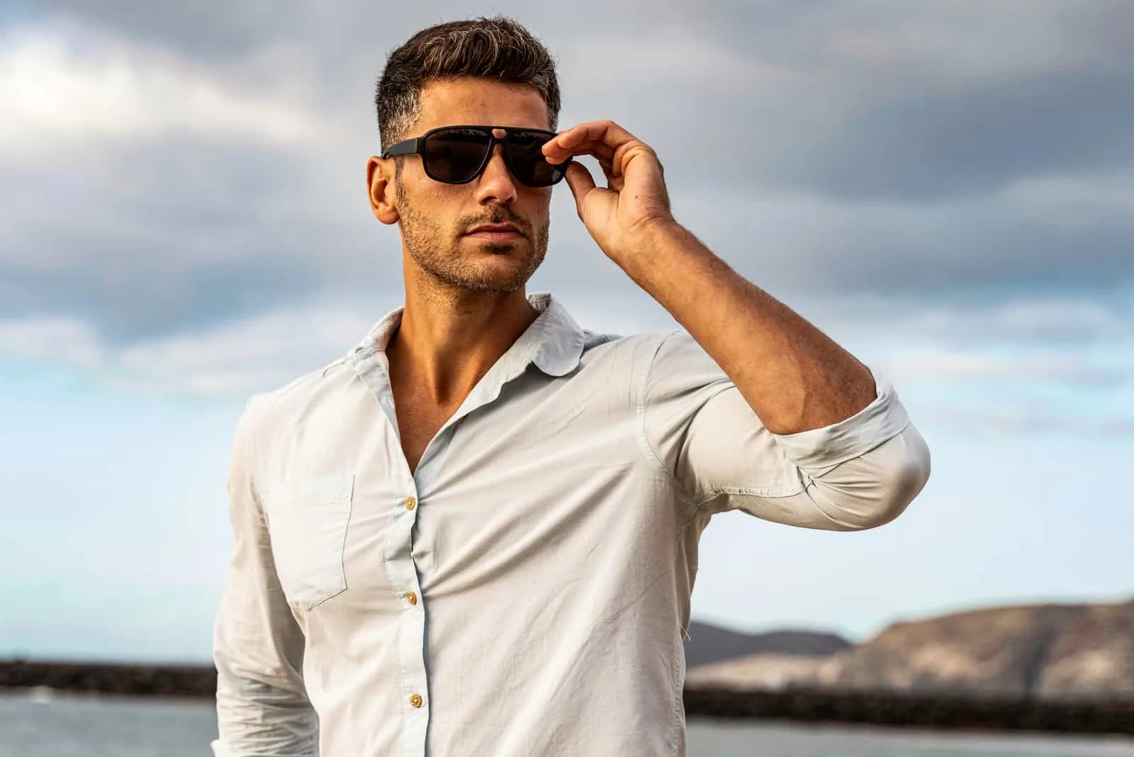 Gorgeous stylish man wearing fashionable shirt and sunglasses