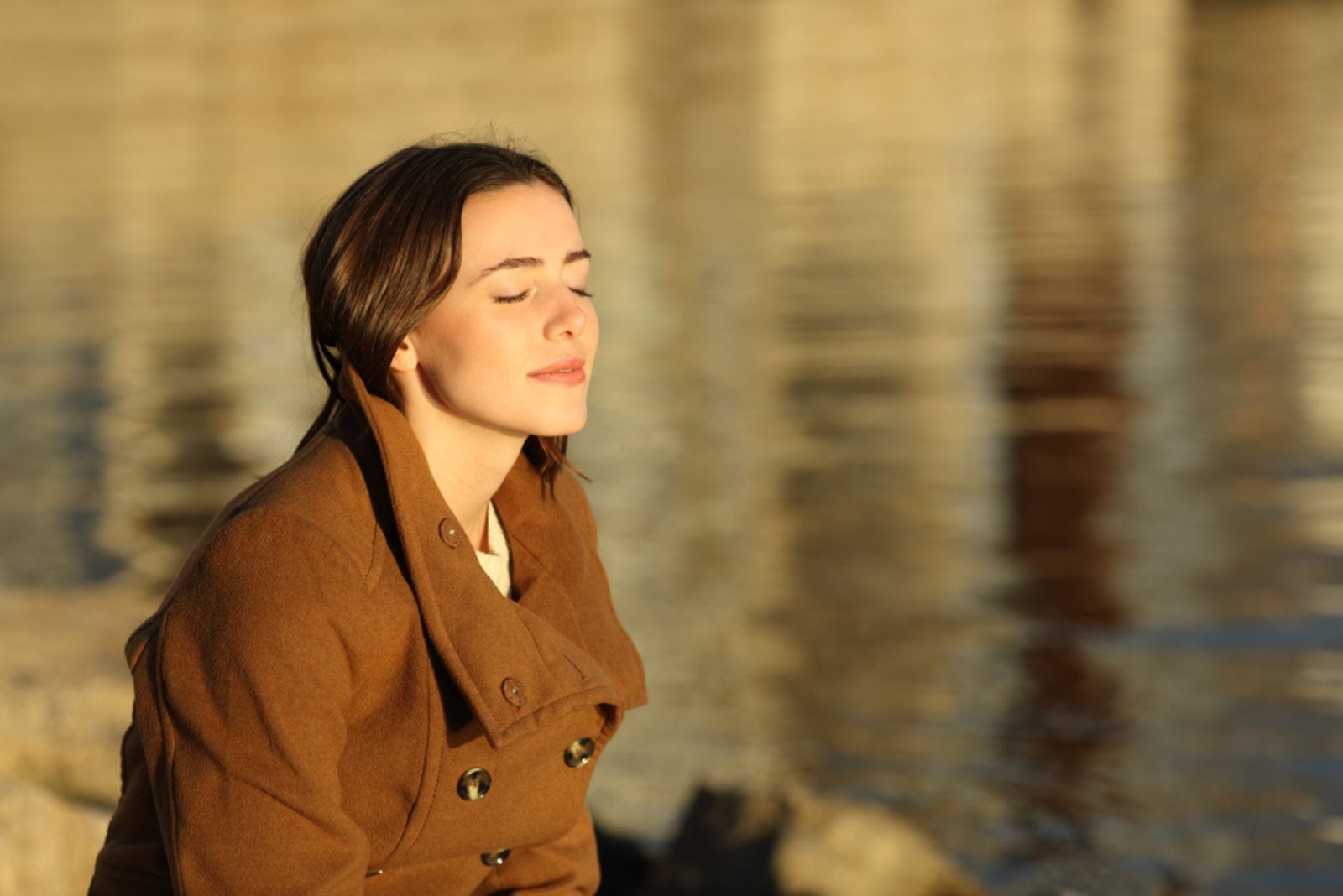 calm woman sitting by the lake