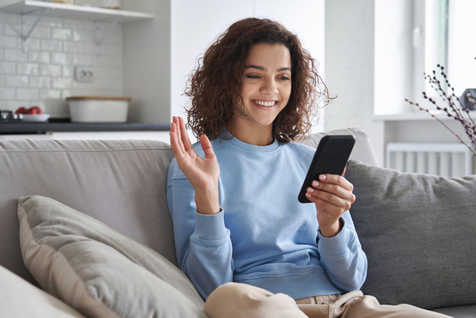 mulher sorridente e feliz a olhar para o telemóvel