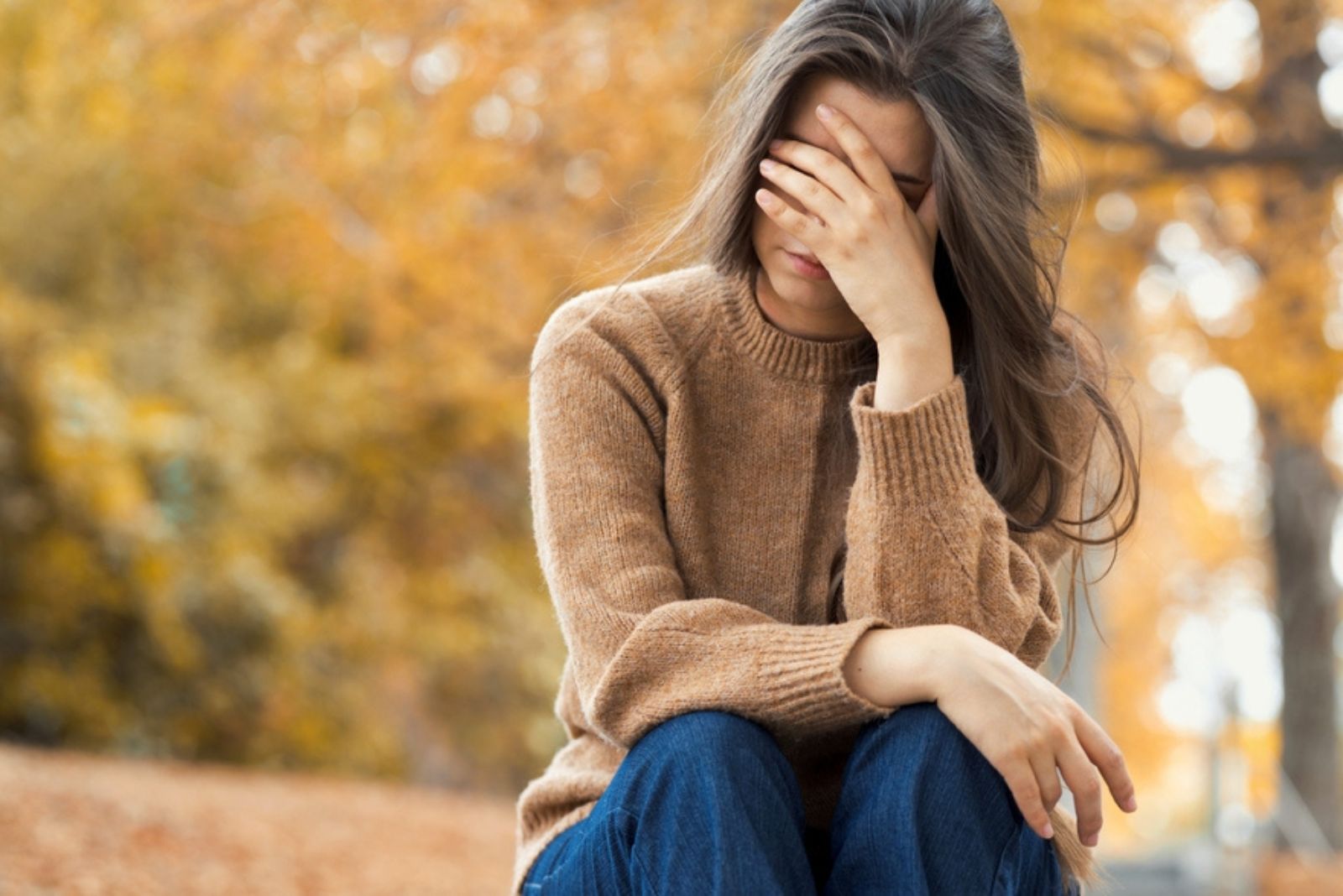 mujer preocupada sentada al aire libre