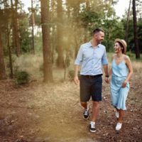 um casal sorridente e amoroso passeia pelo parque