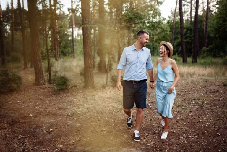 a smiling loving couple sets through the park