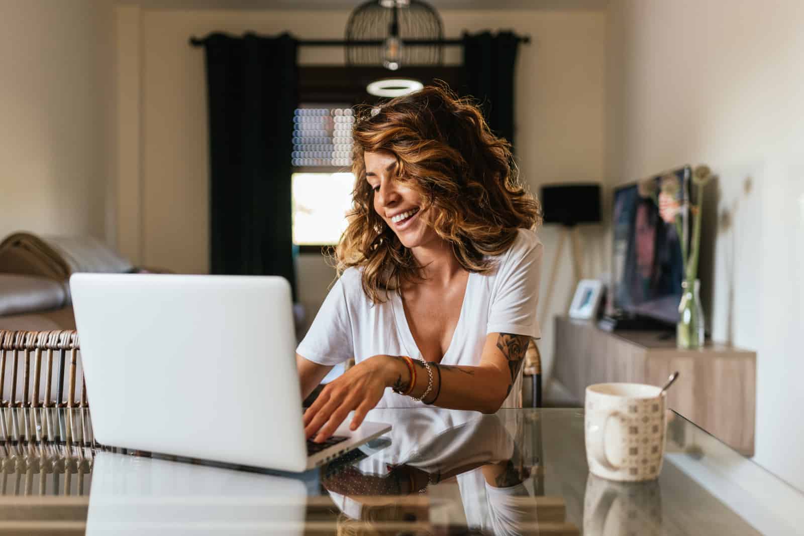 uma mulher de cabelo castanho sentada atrás de um computador portátil