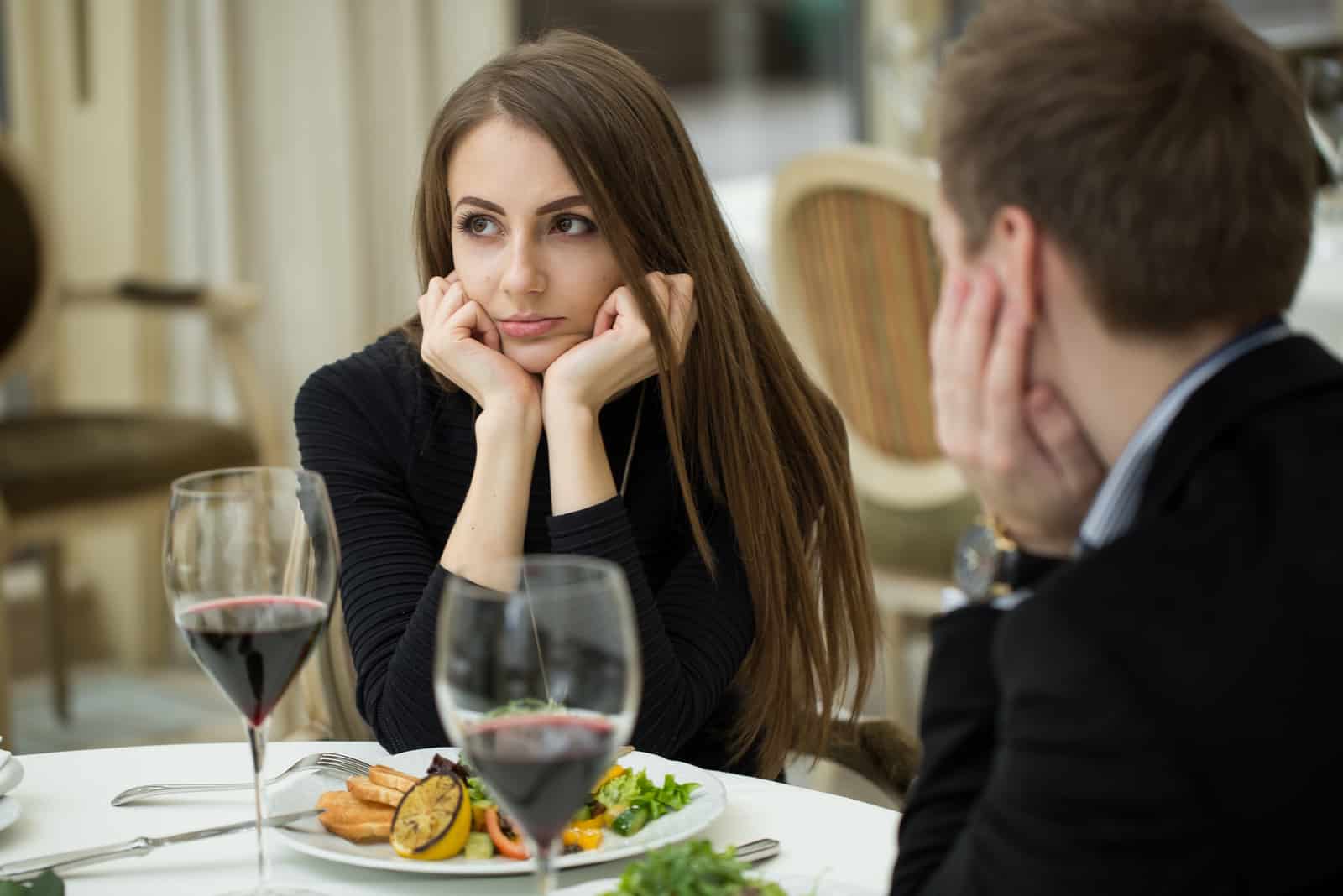 uma mulher confusa senta-se à mesa com um homem