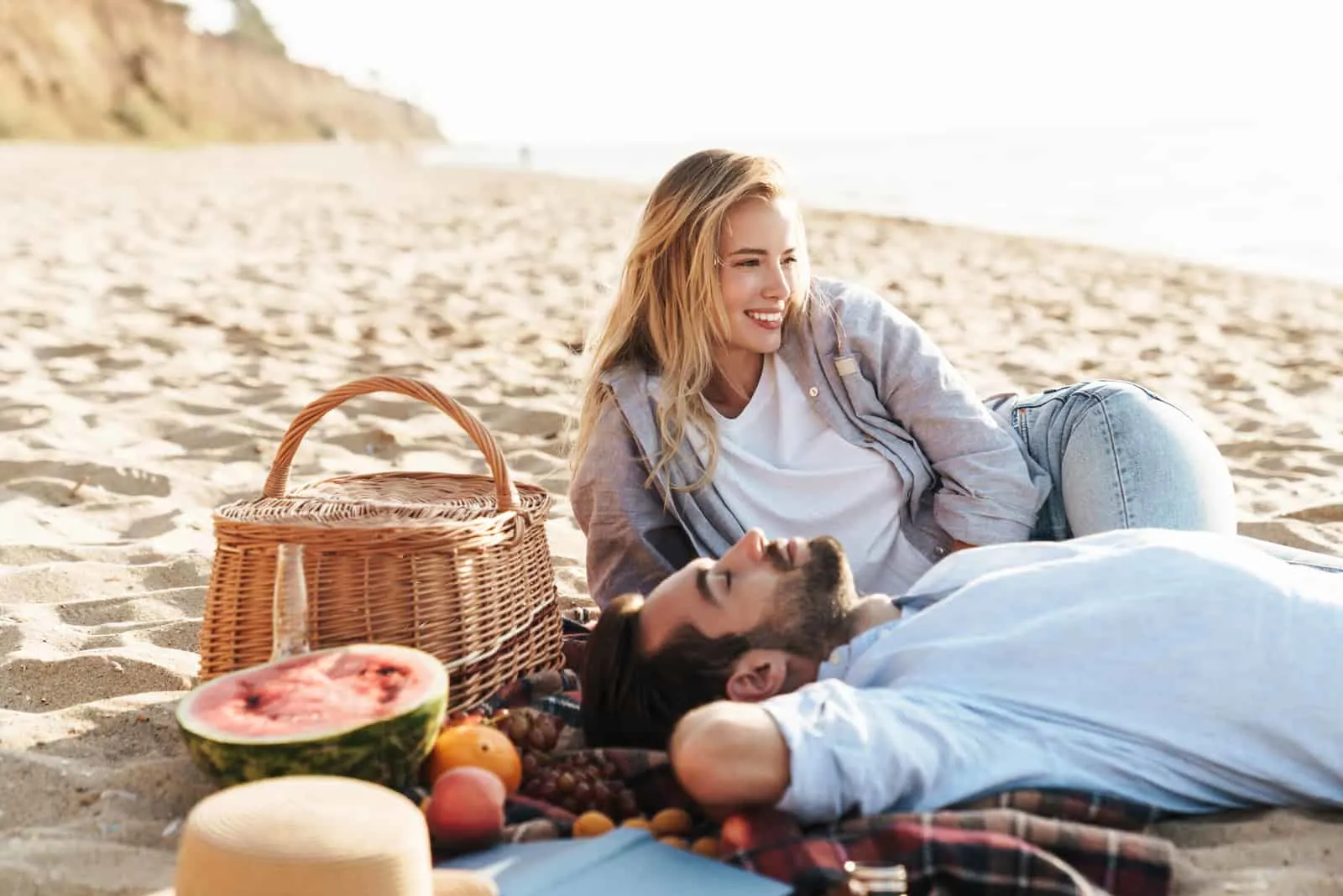 a man and a woman enjoy the beach with breakfast