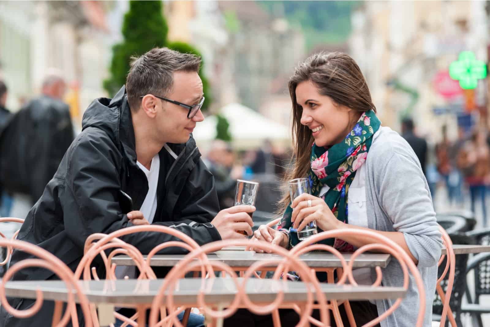 a man and a woman sit outdoors and talk