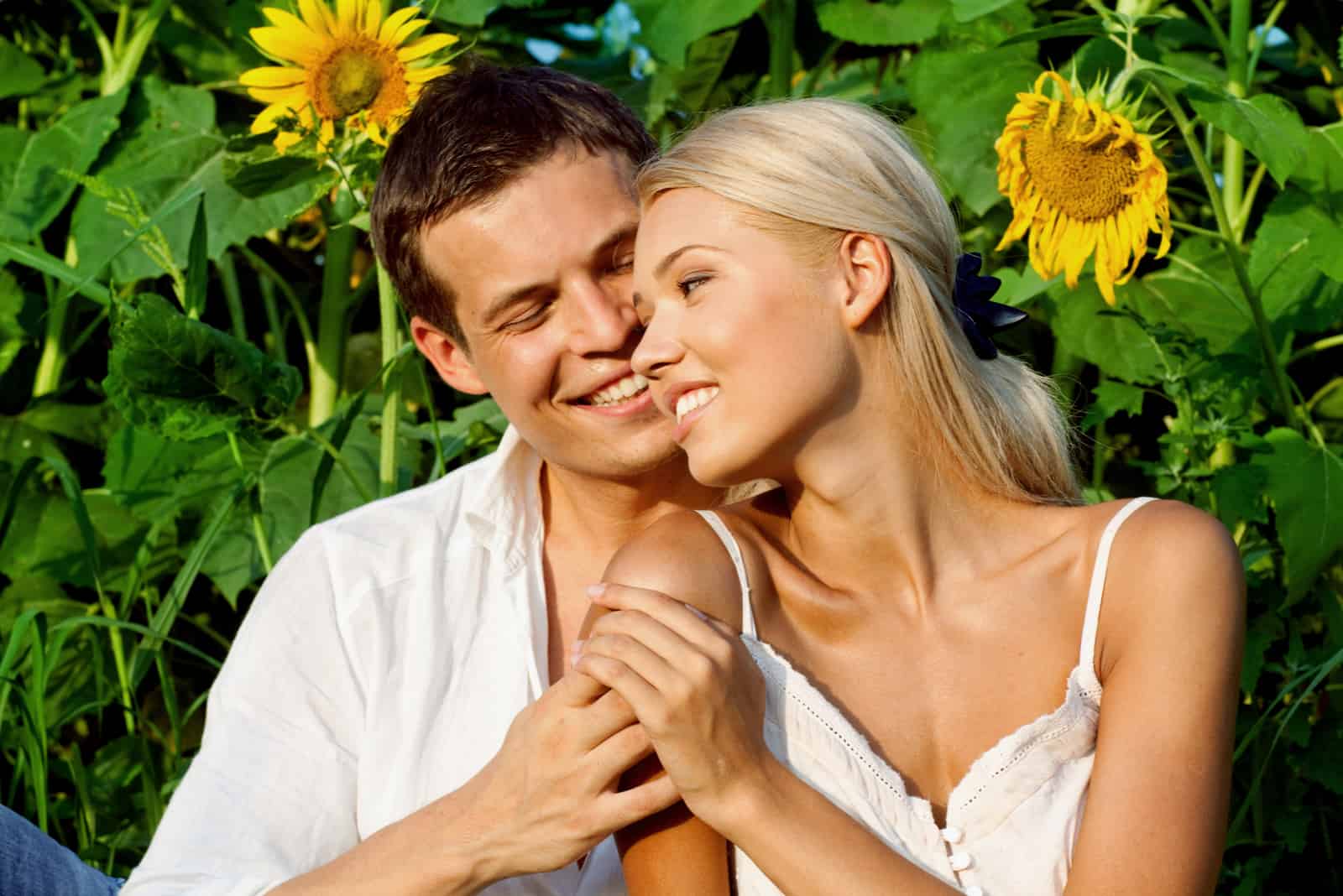 a man hugged a woman in a sunflower field