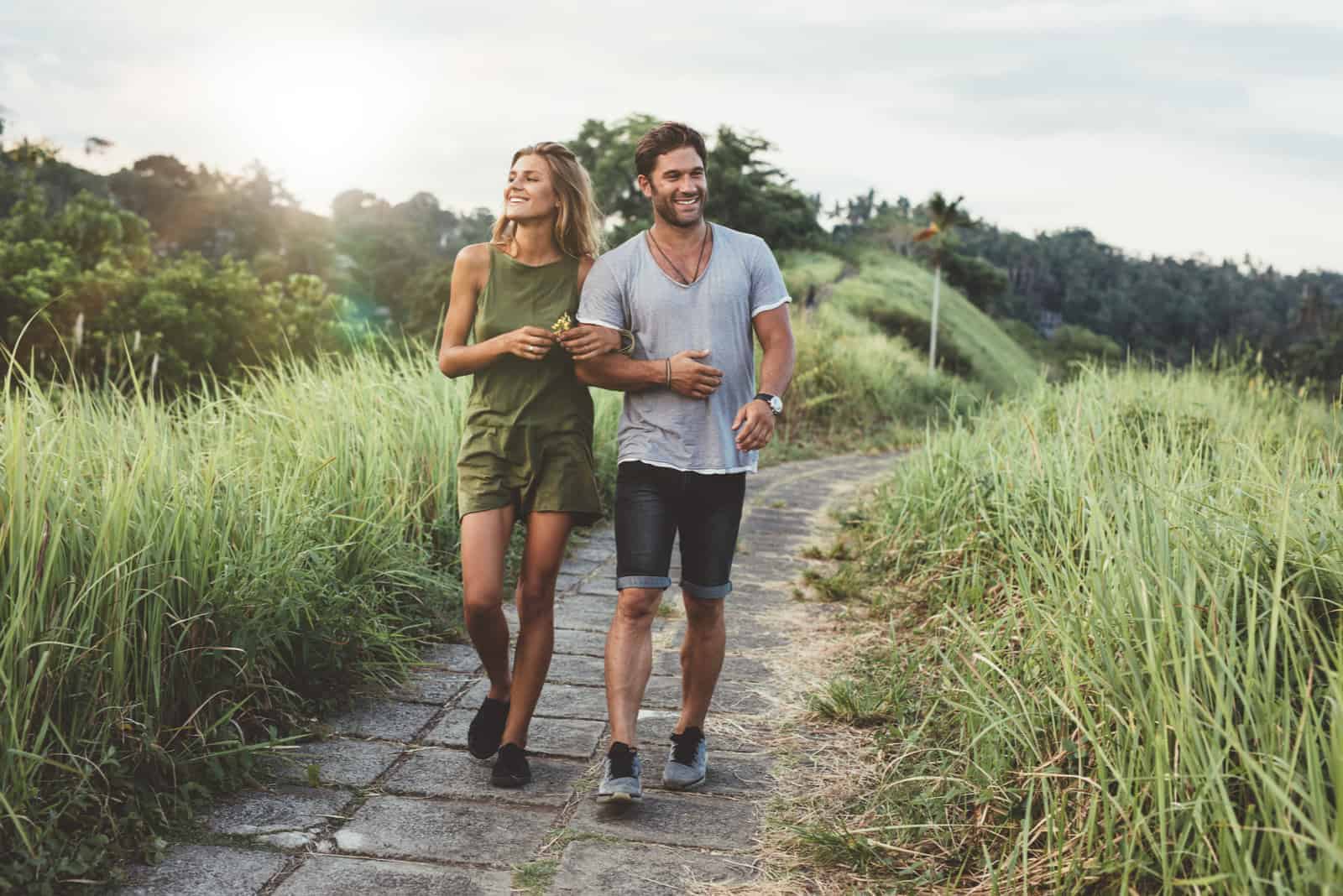 una coppia sorridente attraversa il parco