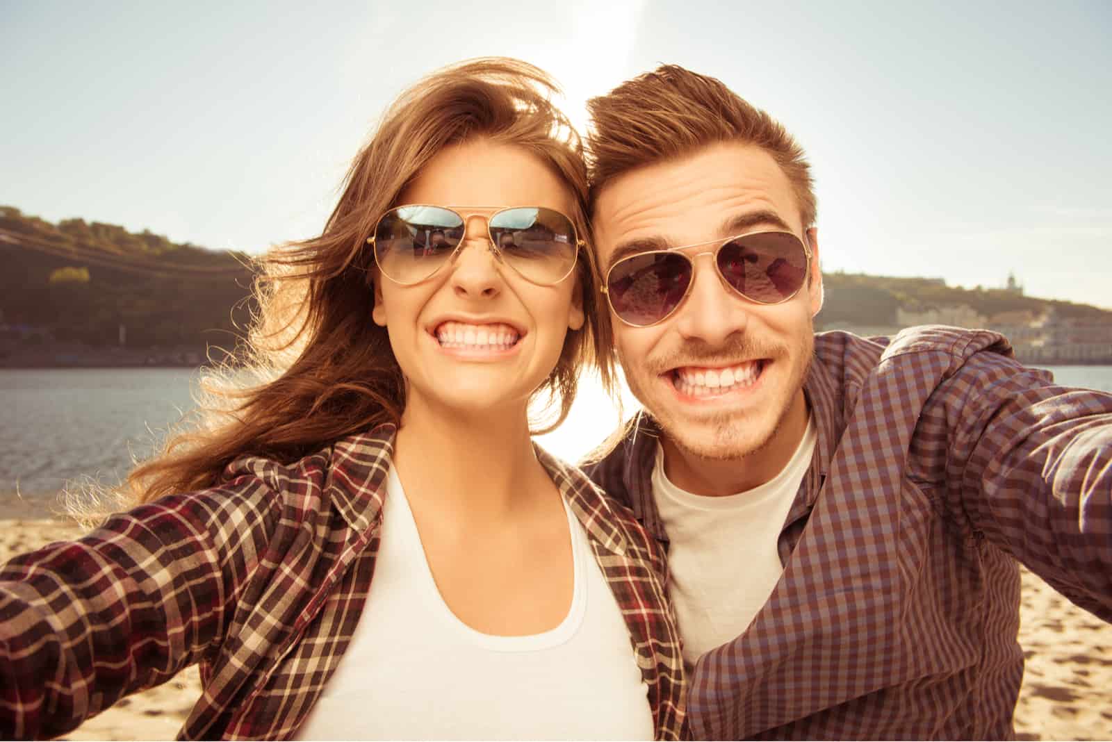 a smiling man and woman are photographed with glasses on their heads