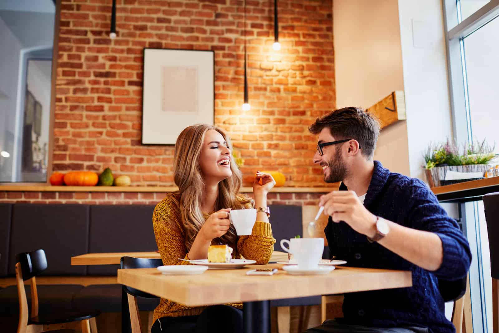 un hombre y una mujer sonrientes tomando café y charlando