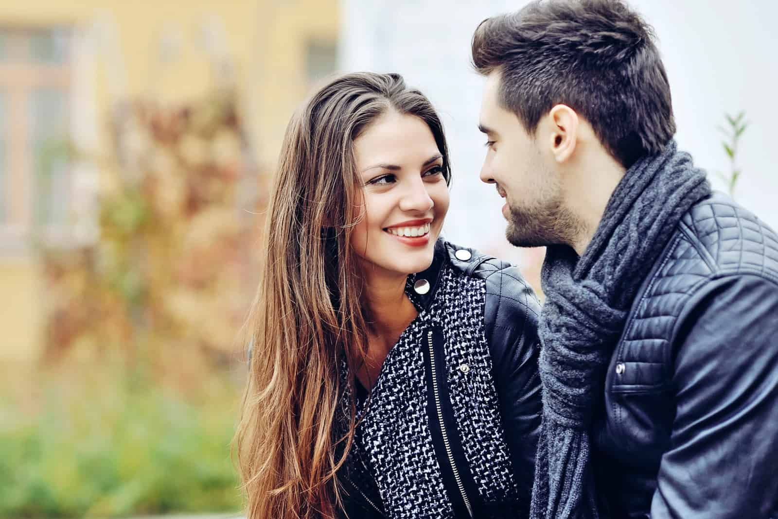 a smiling man and woman sit and talk