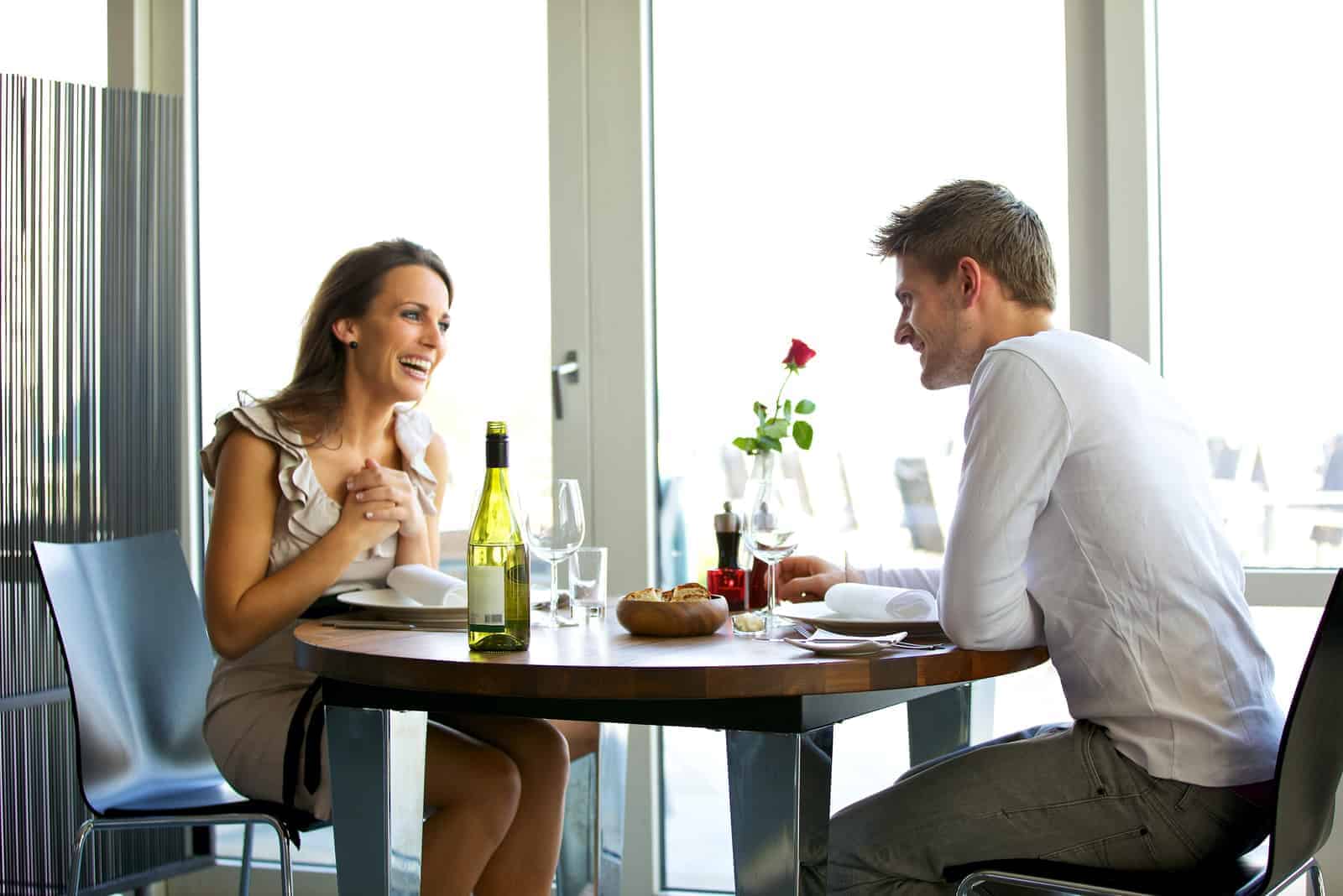 un hombre y una mujer sonrientes sentados en un café