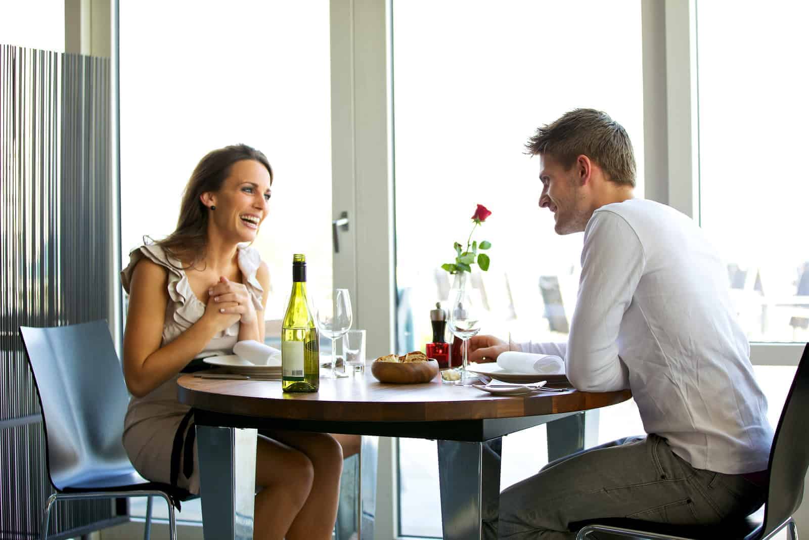 um homem e uma mulher sorridentes sentados num café