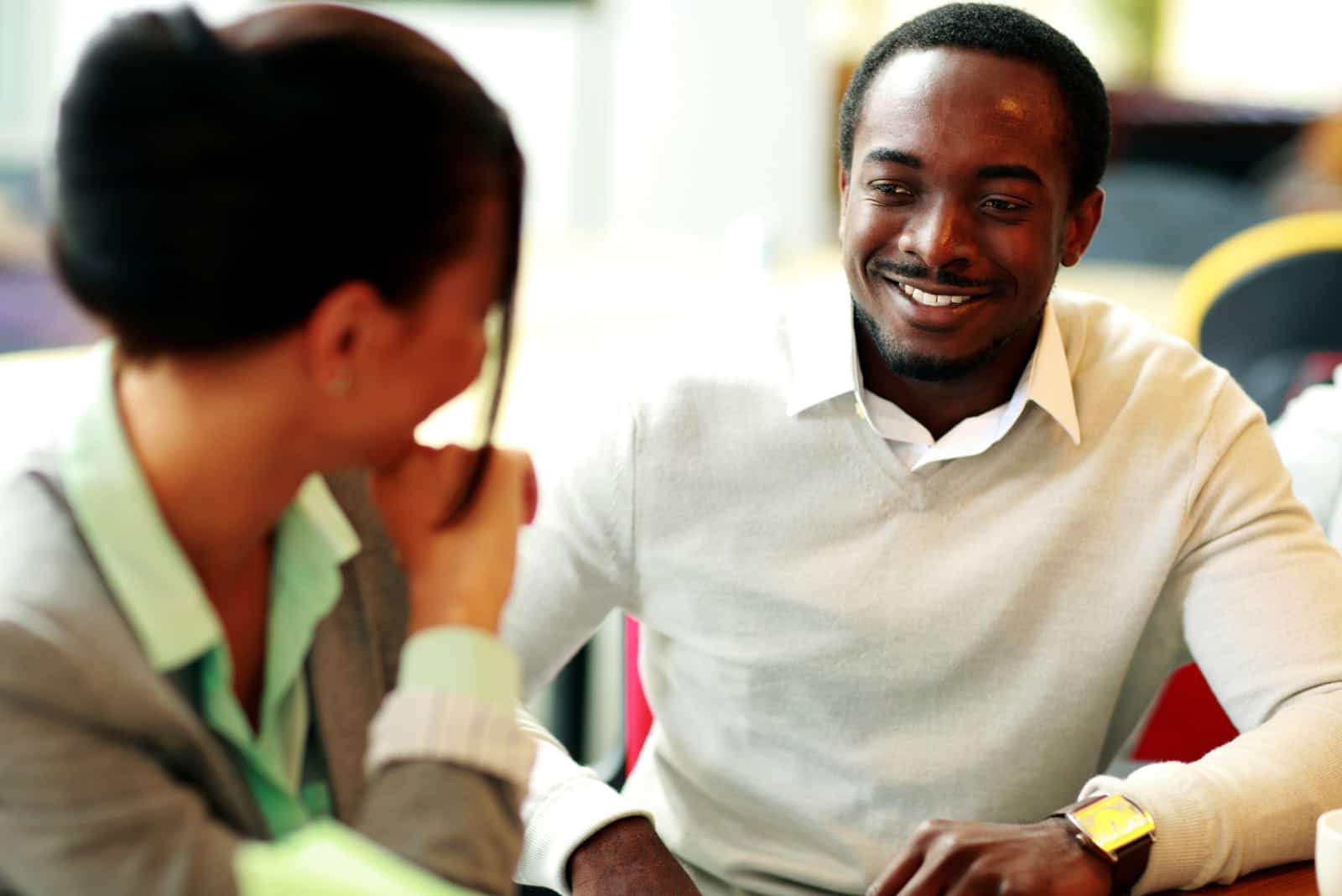 a smiling man talking to a woman