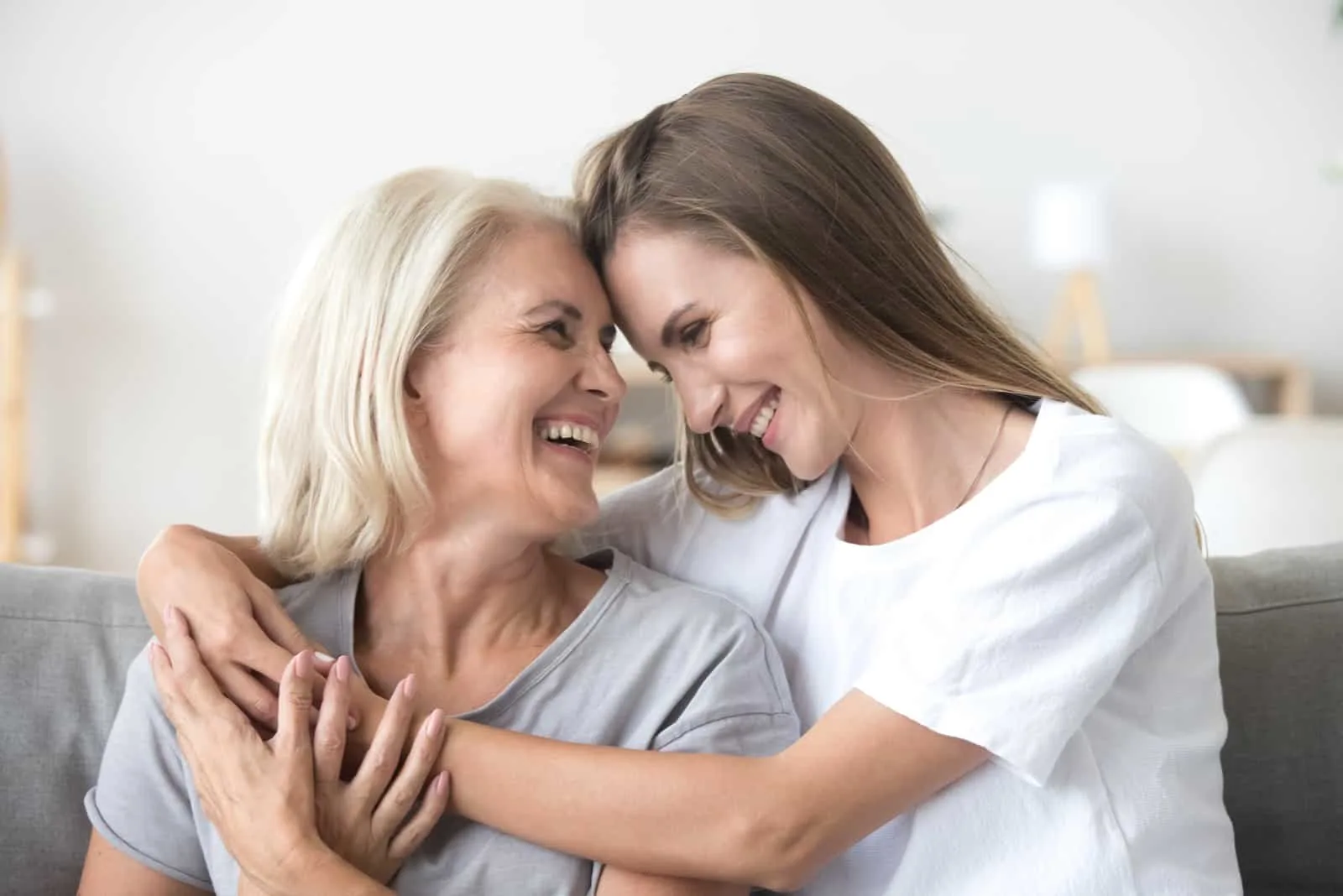a smiling woman sits with her mom in her arms