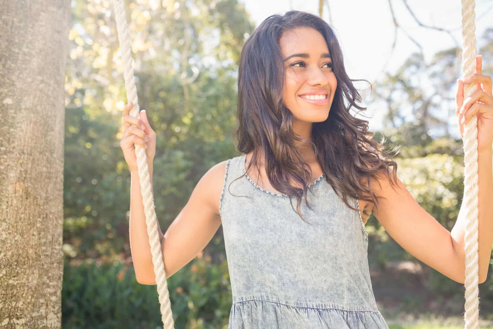 a smiling woman with long black hair sways