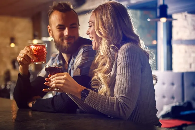 cheerful man and woman having drink together in the bar