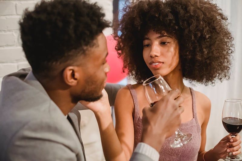 casal a beber vinho e a acariciar-se