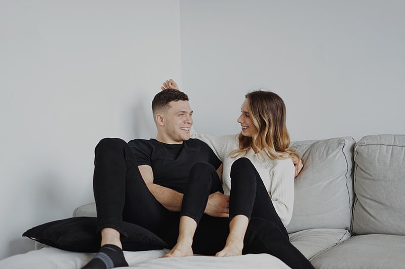 couple sitting side by side on the couch and talking