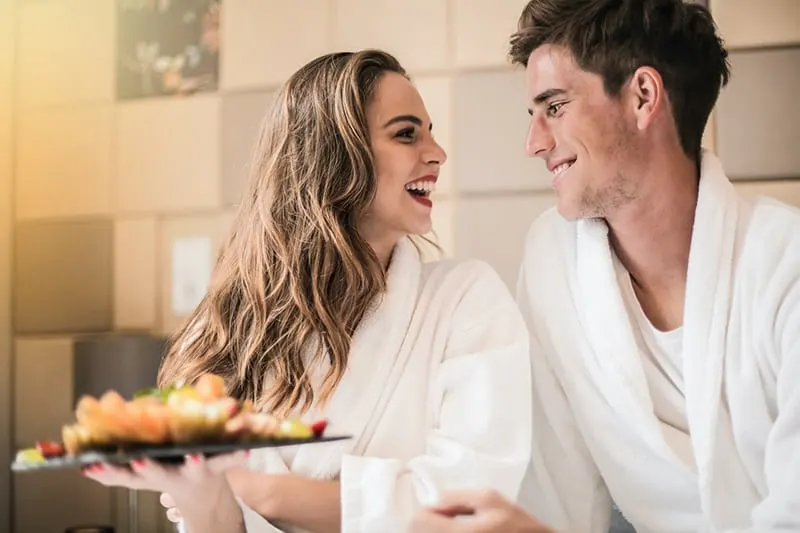 loving couple having fun while eating fruit in the room