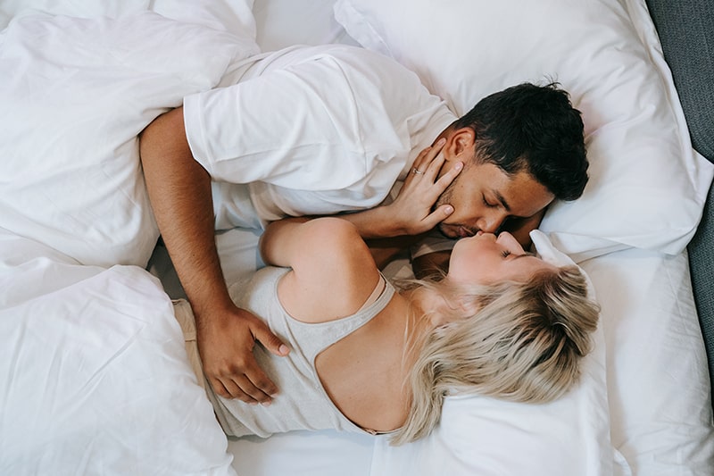 loving couple kissing in the bed