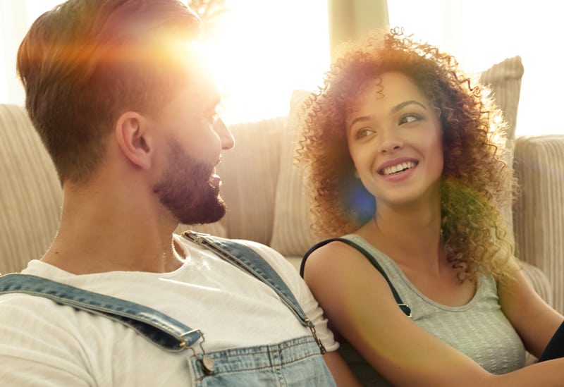 loving couple looking at each other while sitting at home