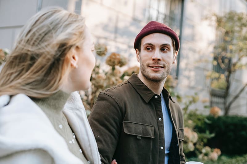 man looking at his girlfriend while walking together on the street