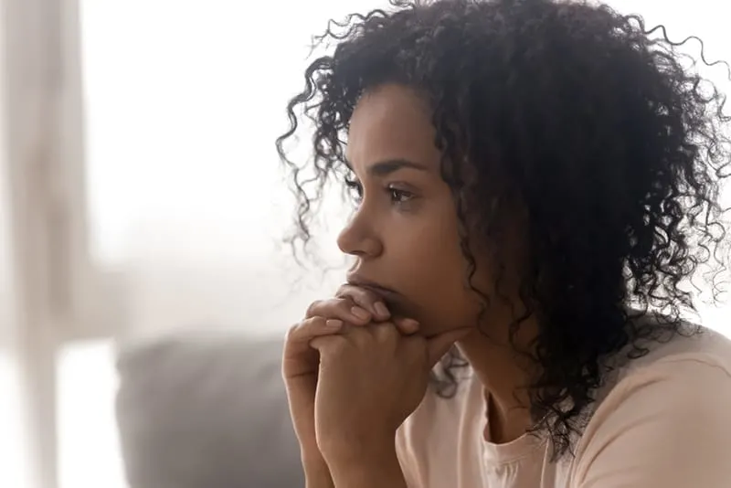 pensive woman thinking about relationship problems sitting at home