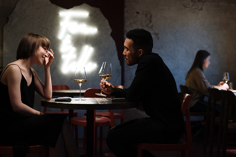 Coppia romantica che beve vino al ristorante per festeggiare un anniversario