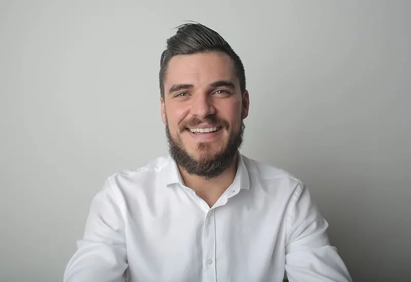 smiling bearded man in white shirt