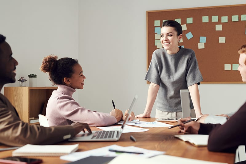 smiling woman talking with colleagues at the meeting